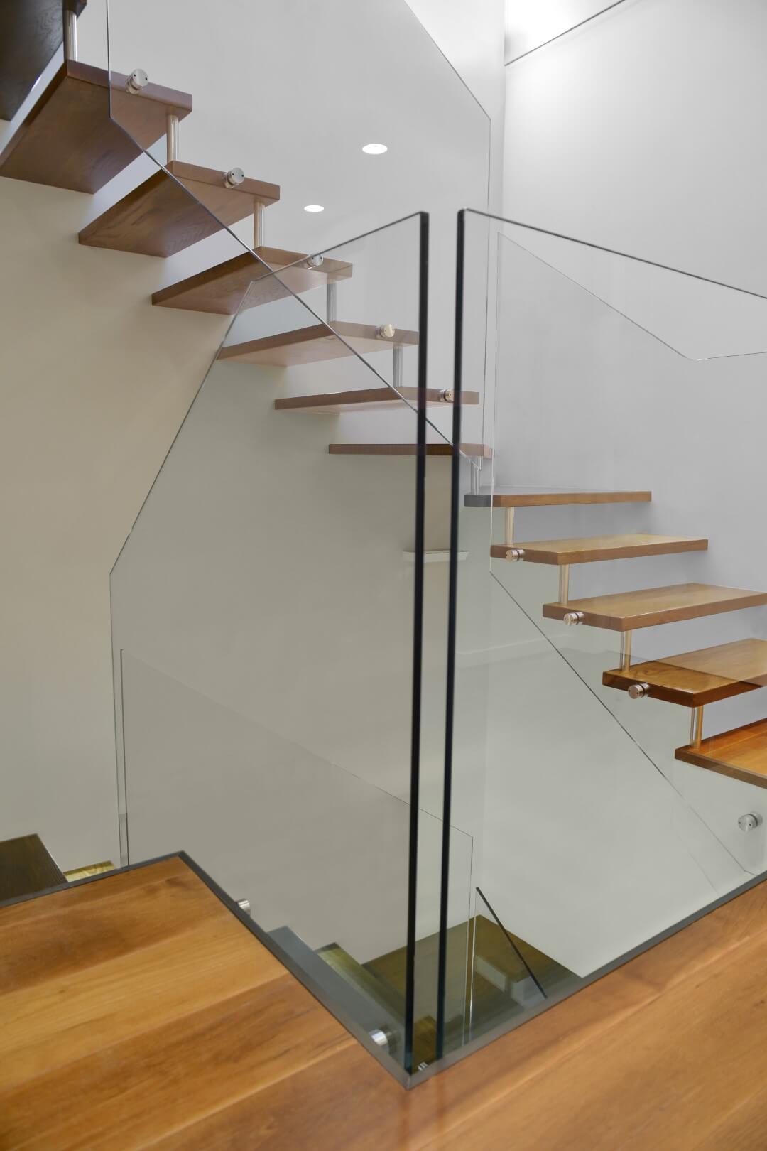 שני גרמי מדרגות עץ תלויות מבעד למעקה הזכוכית