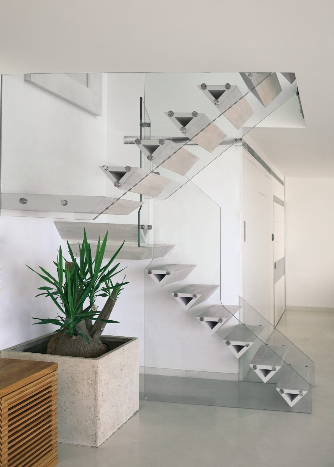 מדרגות עץ האלון כאילו תלויות באוויר בין שני מעקי זכוכית