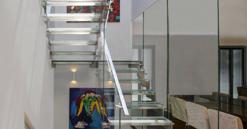 ארבעה גרמי מדרגות זכוכית ונירוסטה עולים בין מפלסי הפנטהאוס וחולפים ליד תמונת הכבשה של קדישמן