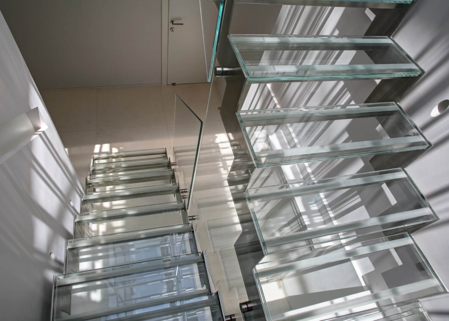 מדרגות זכוכית על קונסטרוקציות נירוסטה עם מעקה זכוכית אקסטרה קליר ומאחזי נירוסטה תלויים על הזכוכית
