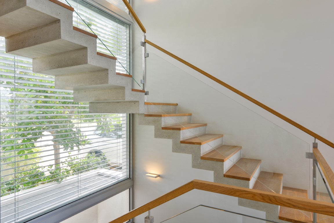 מדרגות עץ משולבות עם מעקה זכוכית וידיות עץ