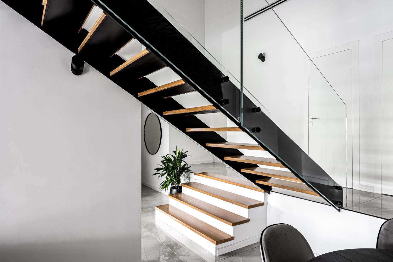 מדרגות ברזל שחור, שלבי עץ אלון אמריקאי ומעקות זכוכית מודרניים במכבים