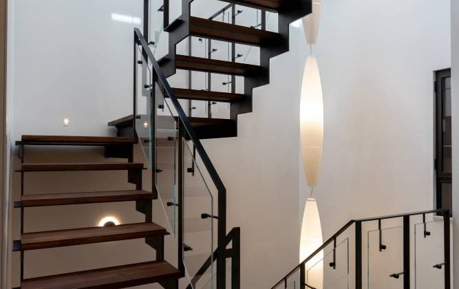 מדרגות ברזל בצבע שחור עם מדרגות אגוז אמריקאי עם מעקה ברזל וזכוכית