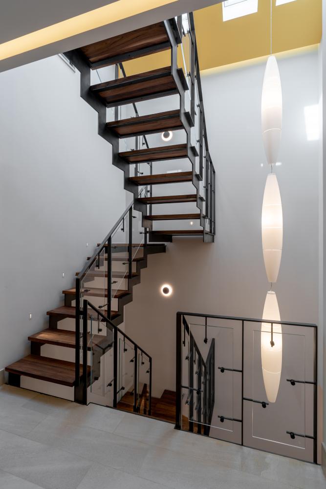 מדרגות ברזל בצבע שחור עם מדרגות אגוז אמריקאי עם מעקה ברזל וזכוכית